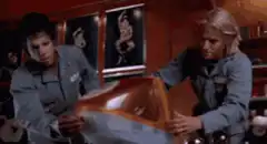 Two men struggle with a large orange object