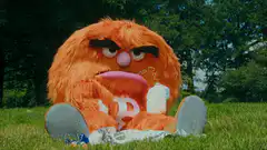 Angry orange monster drinking milk