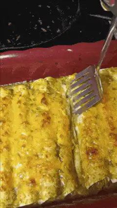 Serving a cheesy enchilada with a spatula