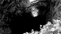 person jumping into a deep dark cave