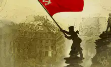 Soldier raising red flag on building