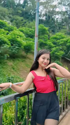 woman in pink top posing on bridge