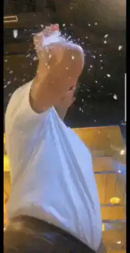 Man in white shirt and sunglasses with powder on hand