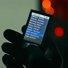 Gloved hand selects music on MP3 player