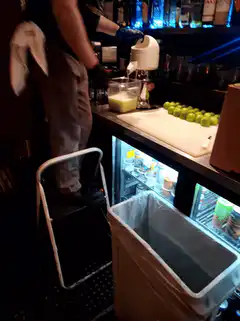 Bartender juicing limes at a bar
