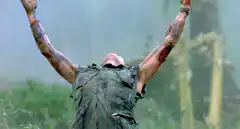 Man in jungle raising arms in triumph