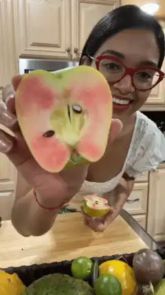 Woman showing pink apple