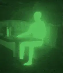 Green night vision person sitting