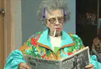 Old lady smoking a cigarette while reading the newspaper
