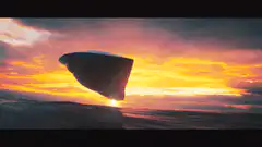 UFO flying over ocean at sunset