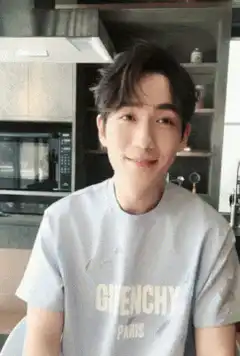 Man in Givenchy shirt smiles and looks down