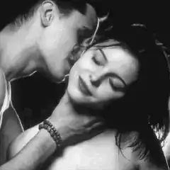 man kissing woman's neck