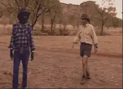 Three people shake hands in the outback