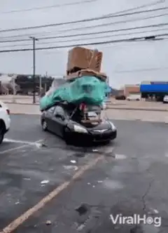 Car overloaded with boxes and tarp