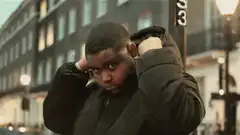 Boy puts on hood on street