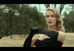 Woman in black dress throws glove at football players