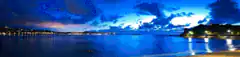 blue night beach with city lights