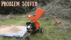 Man feeds branches into wood chipper