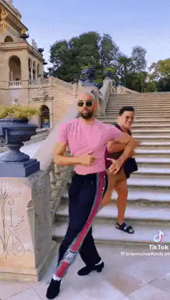 Two men dancing on outdoor stairs
