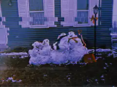 glitchy snowmen in front of house
