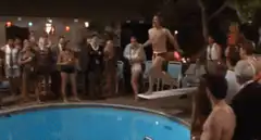Two men dive into pool together