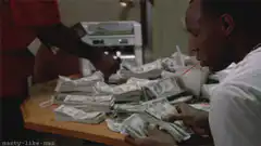Man drinking from a straw while counting money