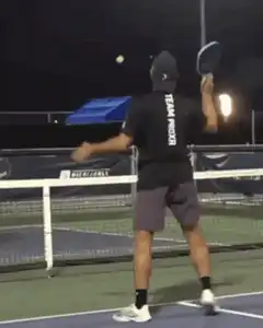 Man hits tennis ball with a blue cooler