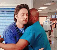 Derek and Preston hug in scrubs
