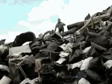 man rolls down a trash pile