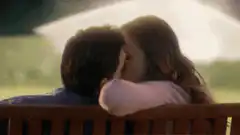 Couple kissing on a bench
