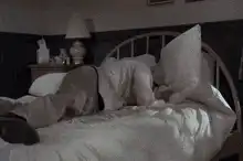 Man rolls over in bed and gives the middle finger