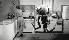 Robot kneels in kitchen