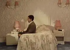 Man sitting on bed in bedroom