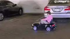 Kid driving toy car in parking lot and street