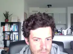 man with curly hair looking down