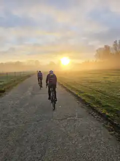 cyclists riding into sunrise