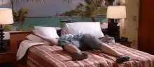 Man flopping onto hotel bed
