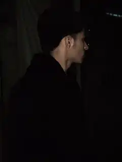 Man in dark hoodie looking right