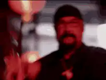 Man in red light blowing out candle