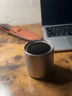 Coffee cup on desk next to laptop