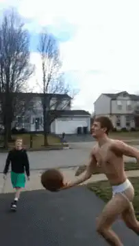 shirtless man in underwear shoots basketball