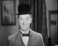 Man in bowler hat smirking