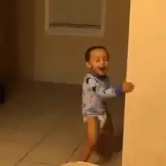 Toddler dancing behind a wall