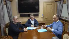 Three men at a table laughing