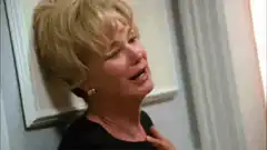 Woman crying and leaning against a wall