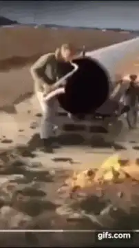 Man playing guitar on a pipe in the desert