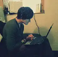 man typing on laptop with red hands