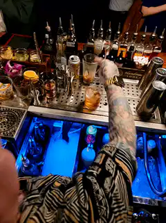 tattooed bartender making a drink