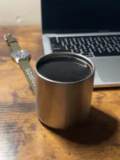 watch and coffee cup on desk