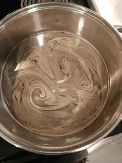 swirling liquid in metal pot